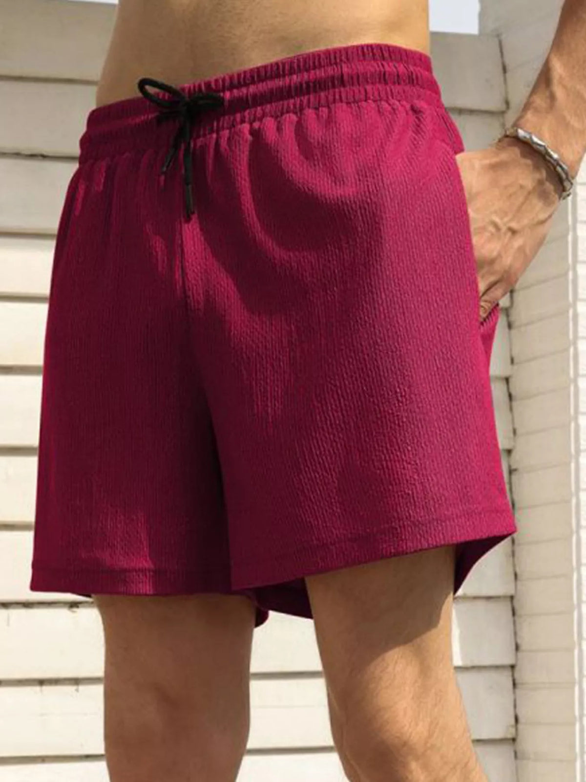 Model wearing magenta drawstring shorts, side view