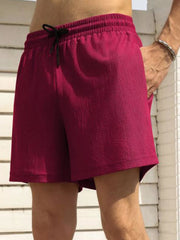 Model wearing magenta drawstring shorts, side view