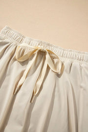 Close-up of the ivory skort's long fabric drawstring and gathered waist.