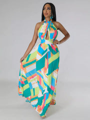 Turquoise geometric halter maxi dress on a model with one hand on her hip and the skirt spread outward.