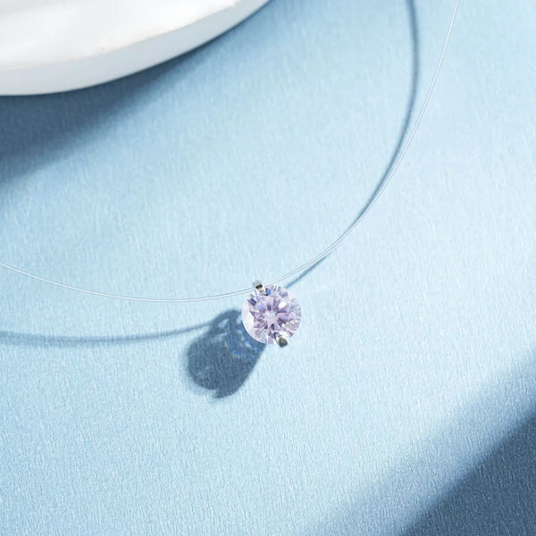 Lavender round zircon pendant necklace with a fine silver-tone chain on blue fabric