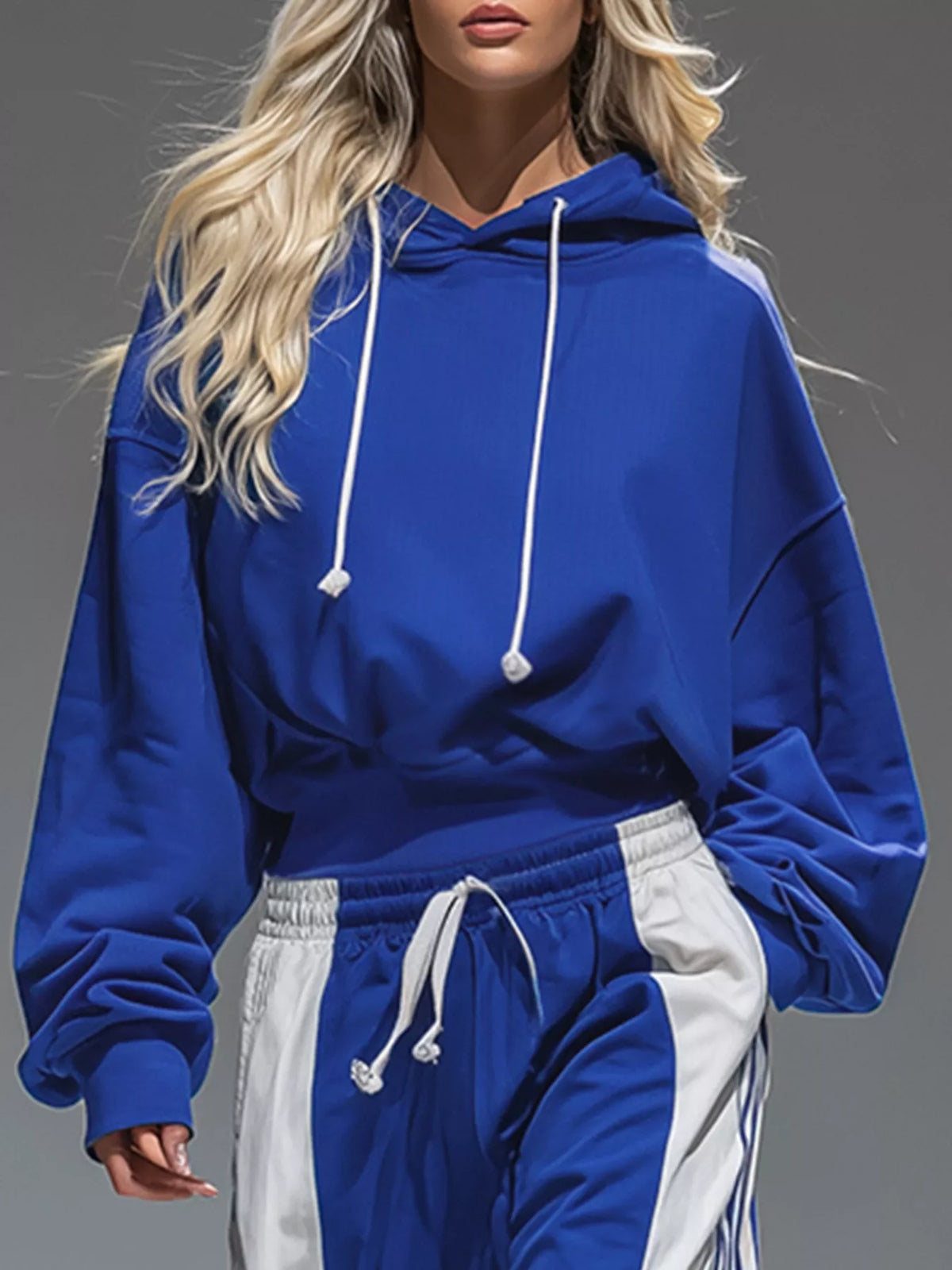 Close-up of the royal blue hoodie's white drawstrings and the pants' elastic waist.