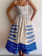 Model in a white spaghetti-strap midi dress with small blue flowers, sardine motifs and a blue hem border.