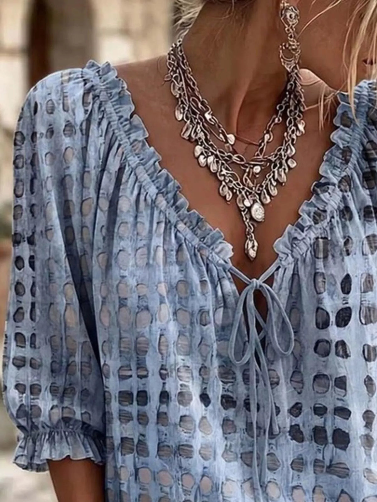 Light blue printed blouse shown at an angle with a gathered three-quarter sleeve.