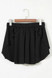 Black skort displayed on a hanger, showing the back and layered hem