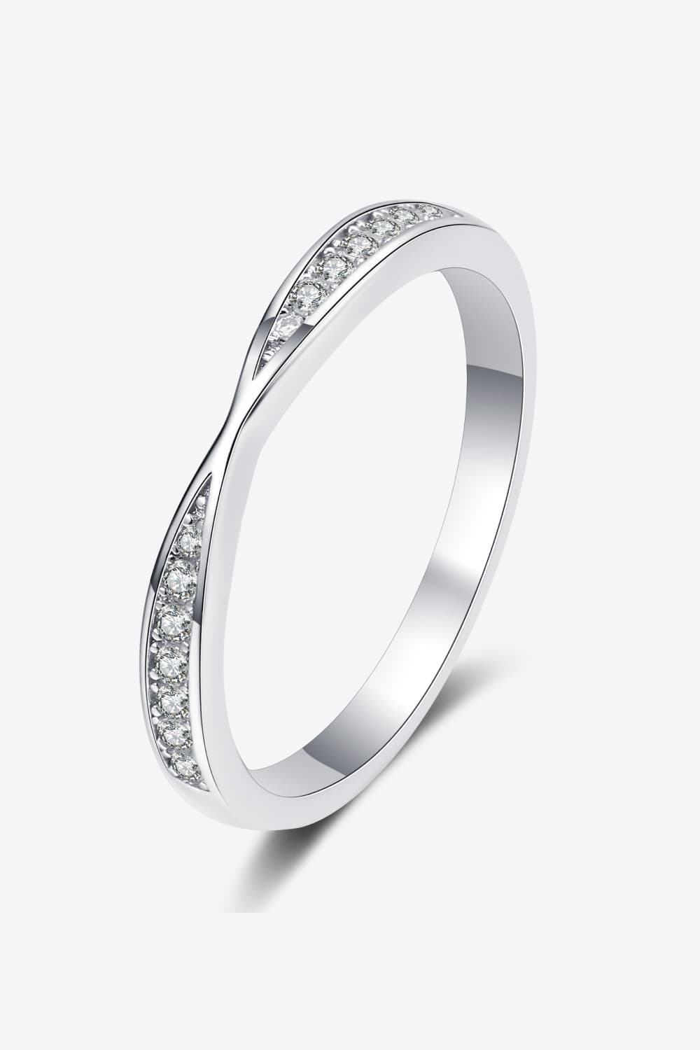 Angled product view of a delicate pavé half-eternity band on white.