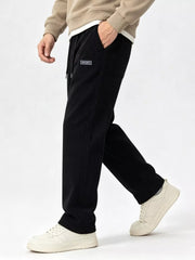 Model stepping forward in black wide-leg pants with one hand in the pocket