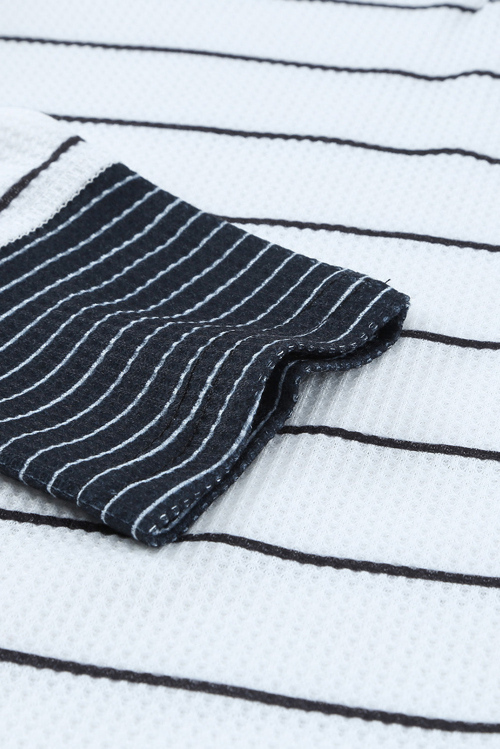 Close-up of striped waffle-knit fabric and dark cuff