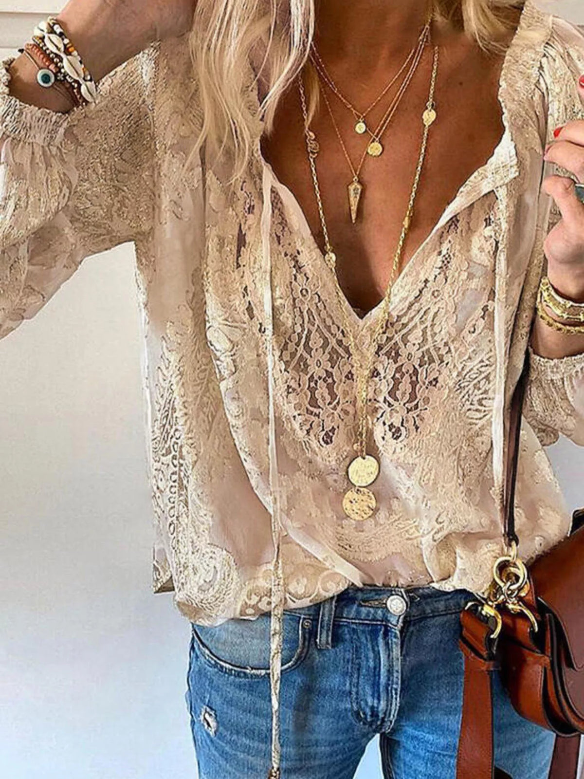 Khaki lace tie-neck blouse with flowing sleeves, modeled with jeans