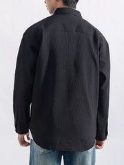 Model wearing the shirt with the collar open over a white T-shirt