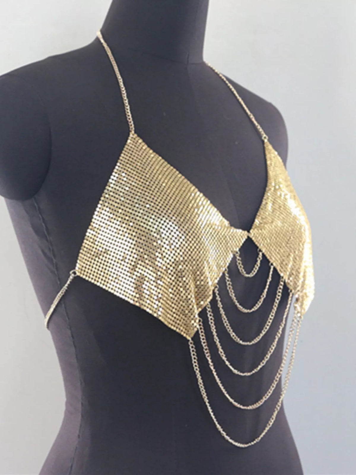 Gold chainmail halter top on mannequin, angled view