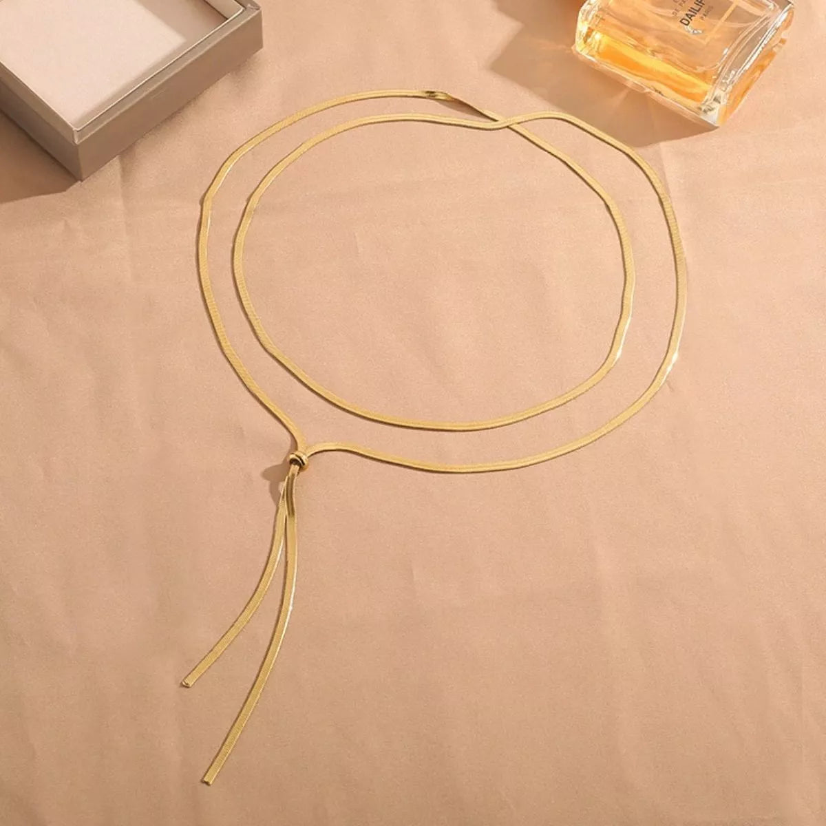Gold layered snake-chain necklace arranged in overlapping loops with long Y ends
