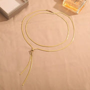Gold layered snake-chain necklace arranged in overlapping loops with long Y ends