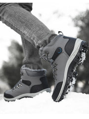 Grey and black lace-up ankle boots with blue accents, worn in snow