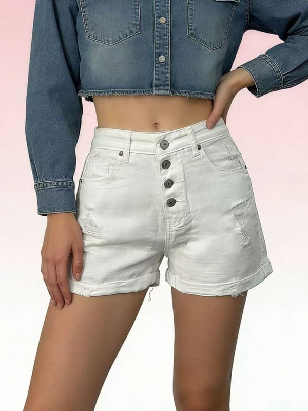 White high-waisted denim shorts with exposed button fly, distressed patches and rolled hems, worn with a denim crop shirt