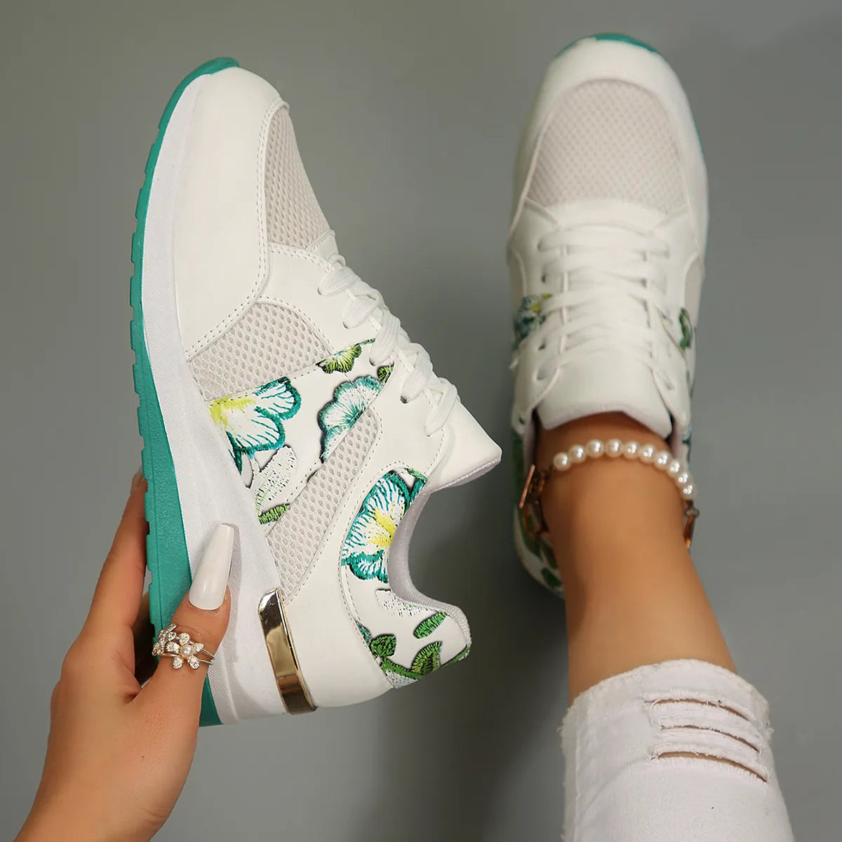 White and turquoise floral sneaker shown from above with sole visible