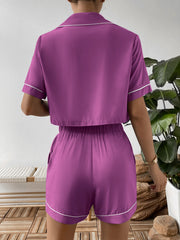 Back view of purple cropped shirt and matching shorts with white piping