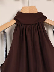 Close-up of gathered fabric at the upper back of the dark brown dress
