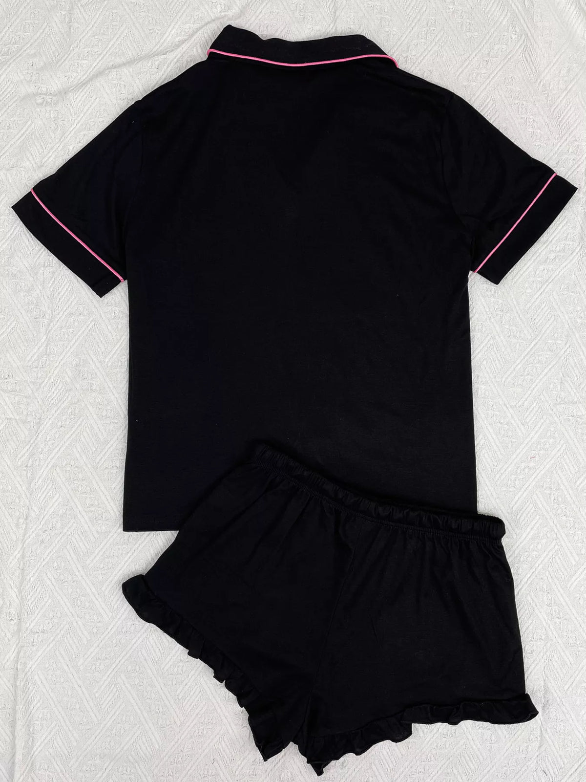 Back view of black button-down pajama top and matching ruffle shorts