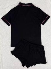 Back view of black button-down pajama top and matching ruffle shorts