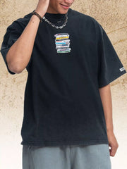 Model wearing a black T-shirt with a small cassette graphic