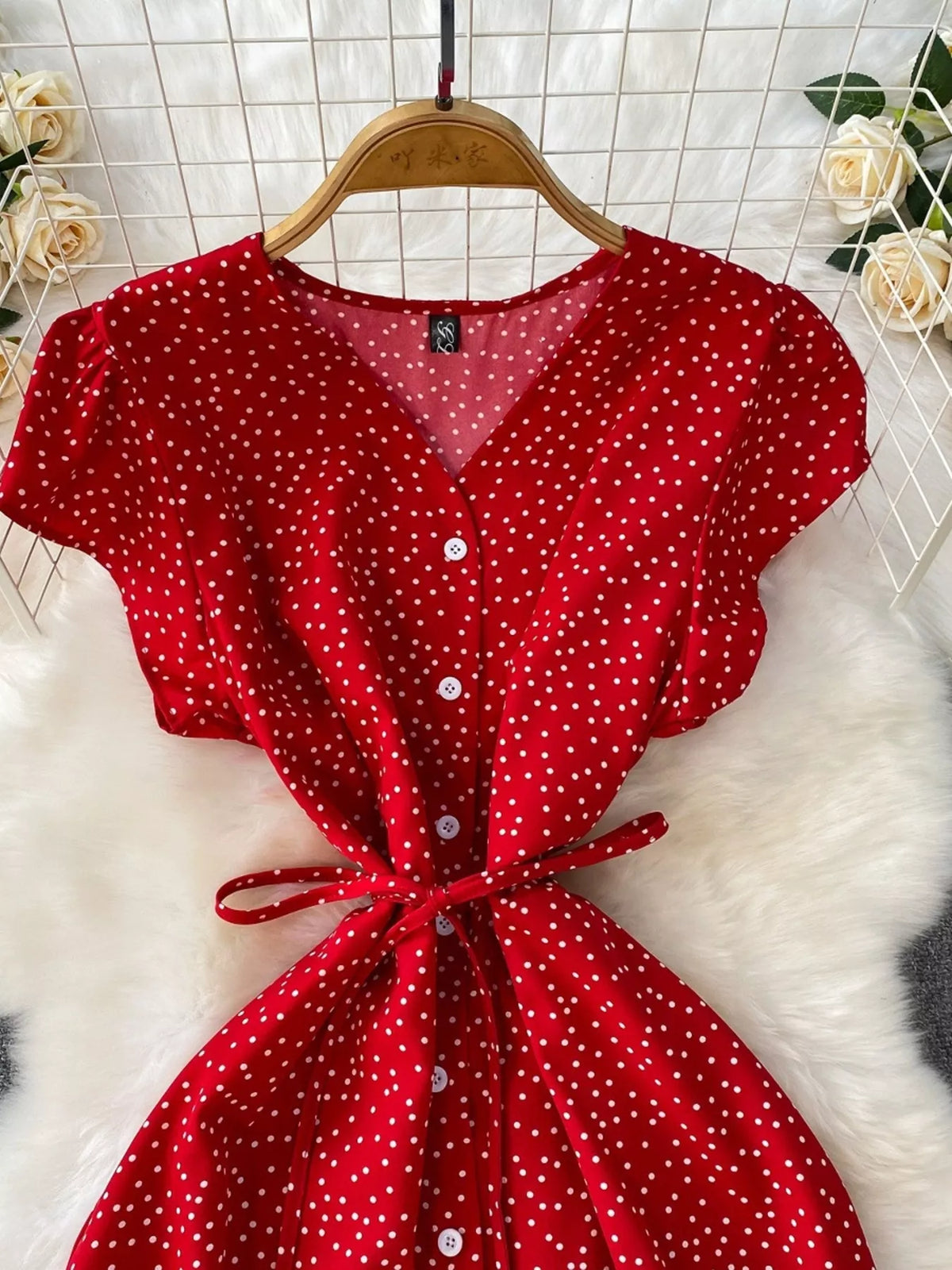 Red dress detail showing V-neck, buttons and tie waist