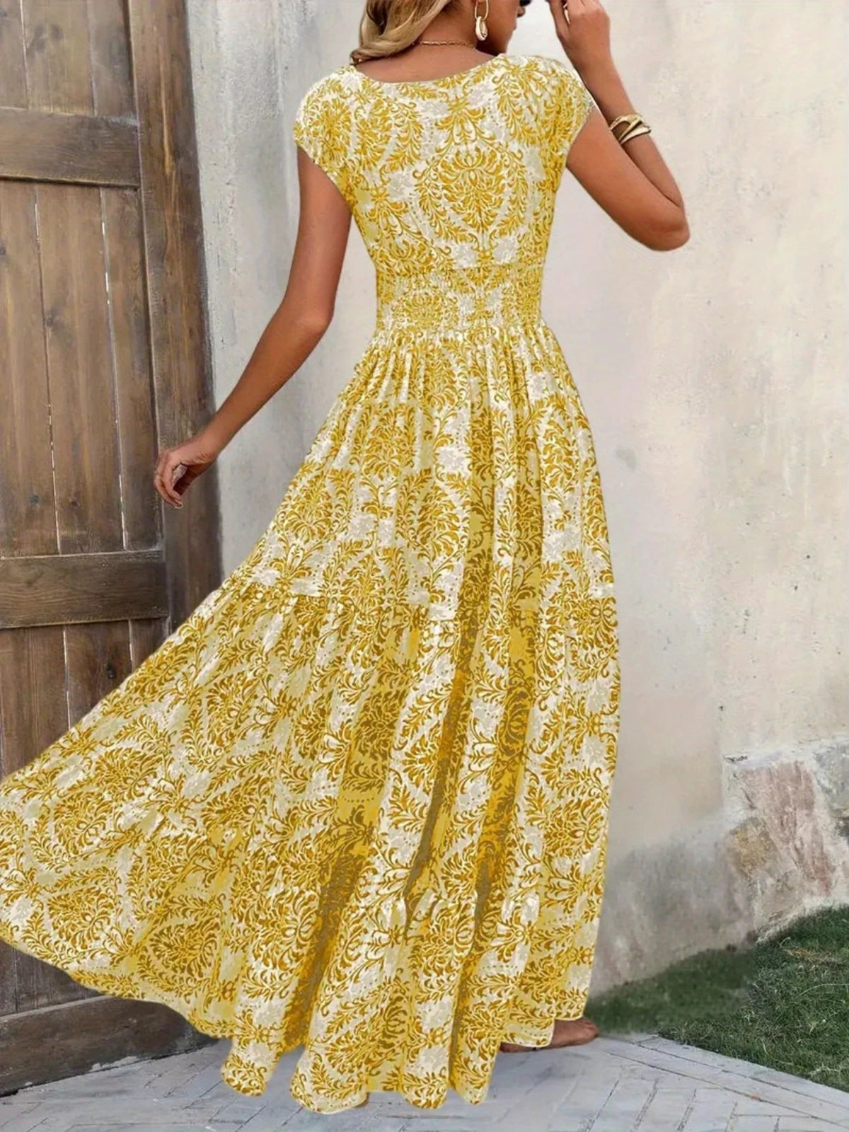 Yellow floral maxi dress shown from the back with cap sleeves and a gathered waist.