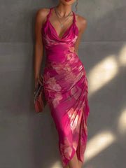 Pink floral halter midi dress with a draped neckline, ruched skirt and front slit, full front view.