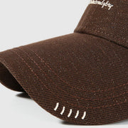 Close-up of the brown cap's curved brim and stitched detailing