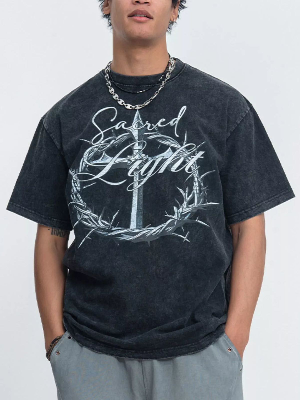 Model wearing washed black tee with ornate circular graphic