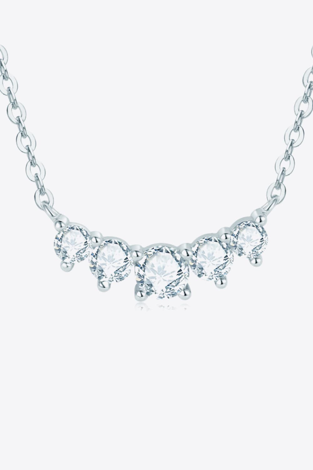 Curved row of clear stones on silver chain shown against white