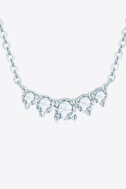 Curved row of clear stones on silver chain shown against white