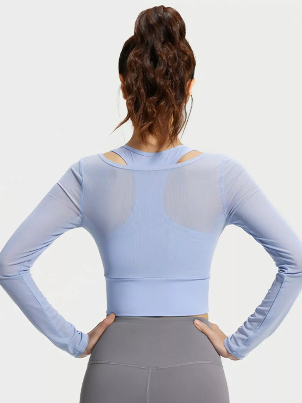 Back view of light blue long-sleeve active top with inner racerback visible beneath the sheer layer