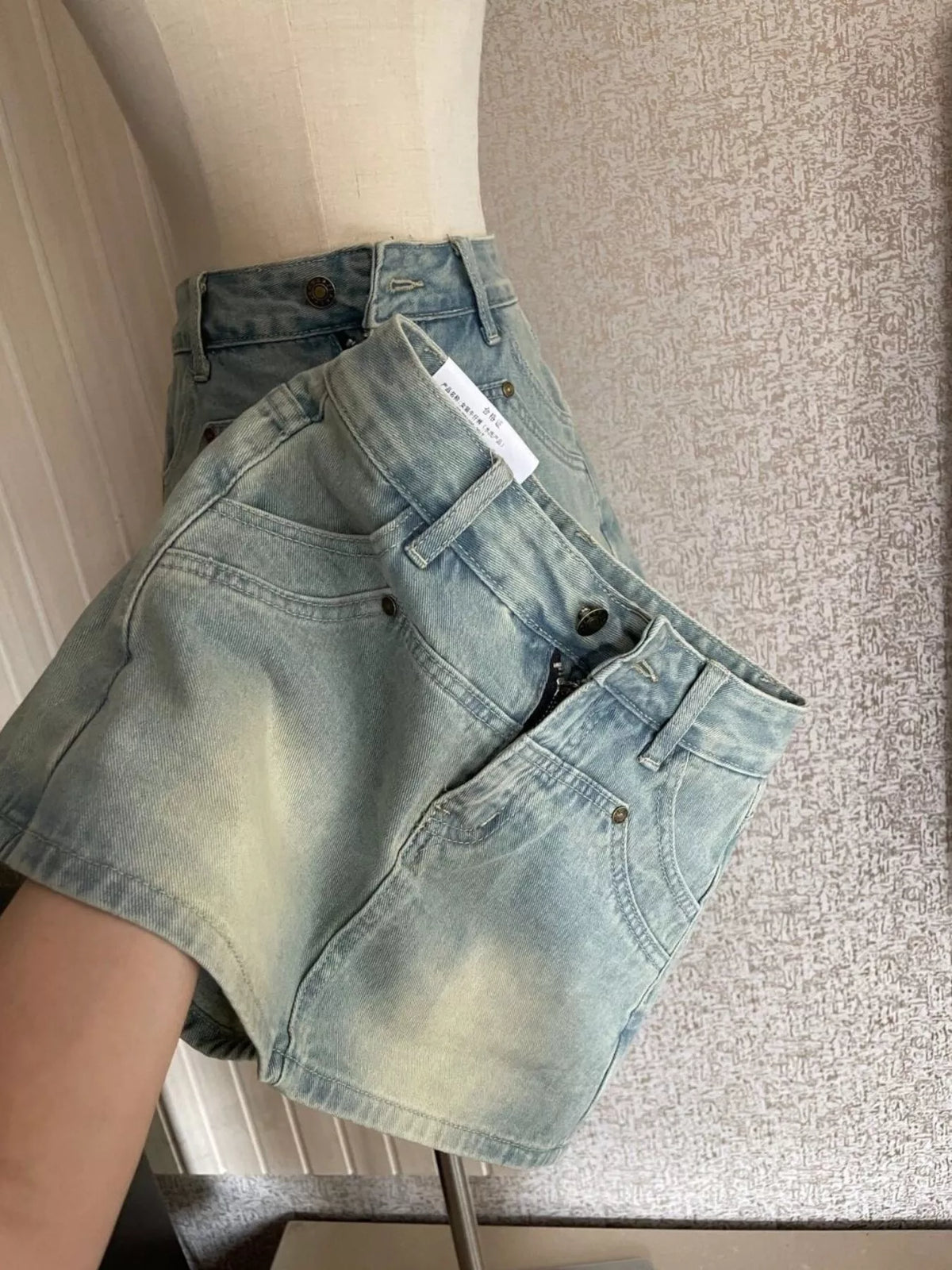 Angled front view of light-wash high-waisted denim shorts