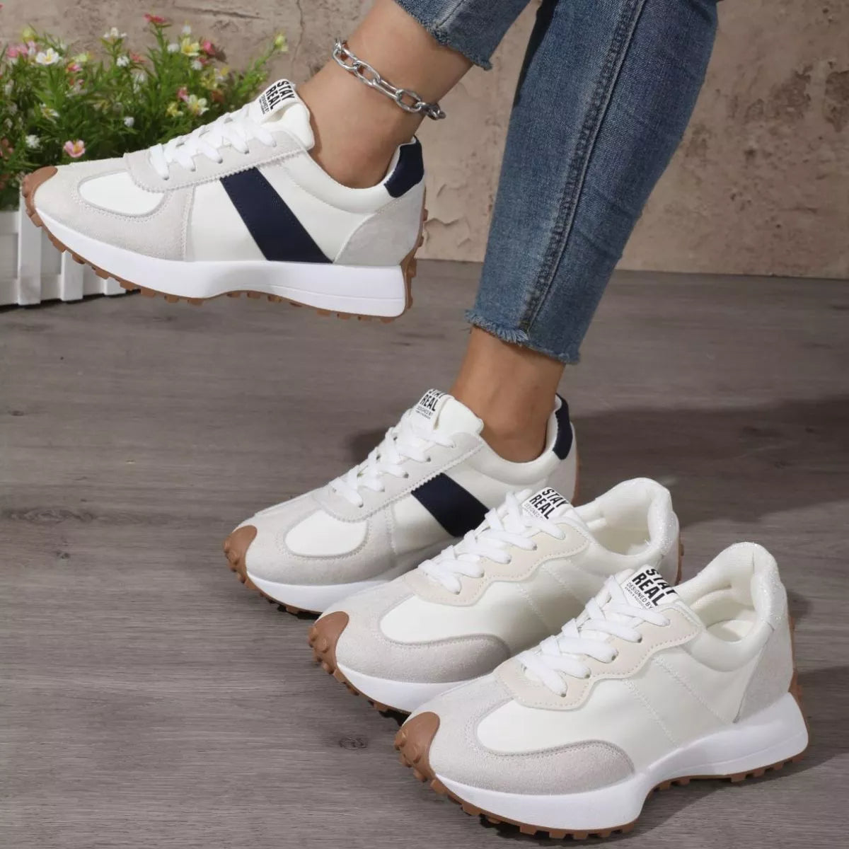 White low-top sneakers with black side panels shown in a group