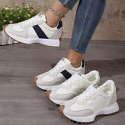 White low-top sneakers with black side panels shown in a group