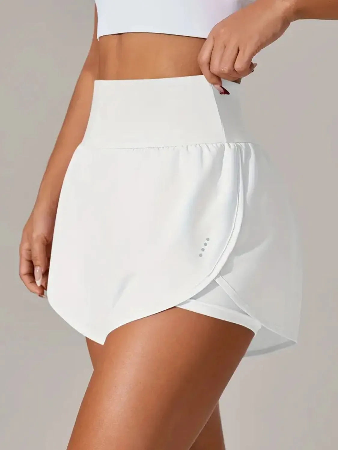 Back view of white active shorts with overlapping skirt-style outer layer