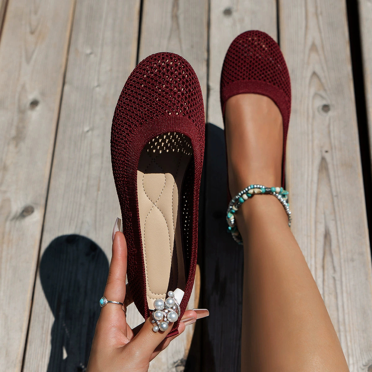 Burgundy mesh flat beside a black flat, viewed from above