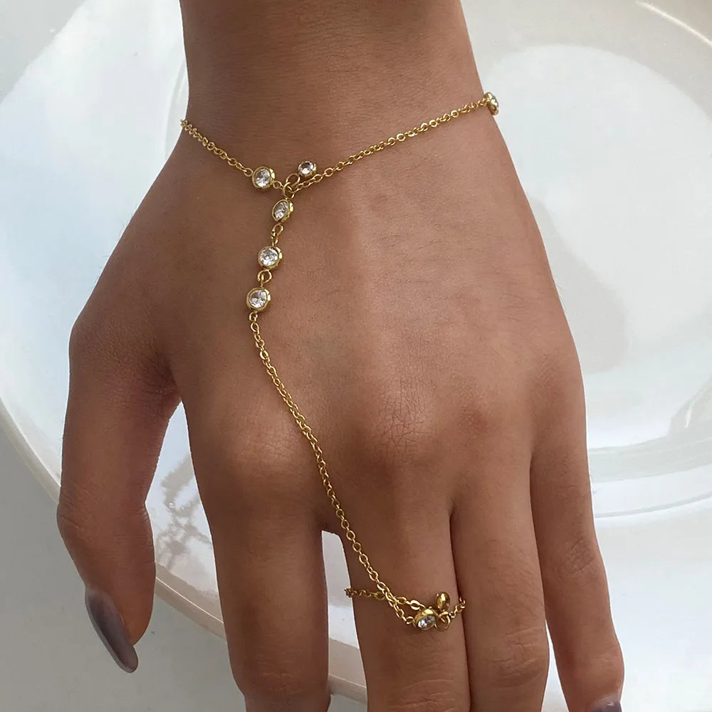 Gold rhinestone hand chain worn across hand and finger