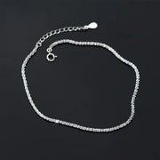 Sterling silver chain bracelet laid out in a rounded loop