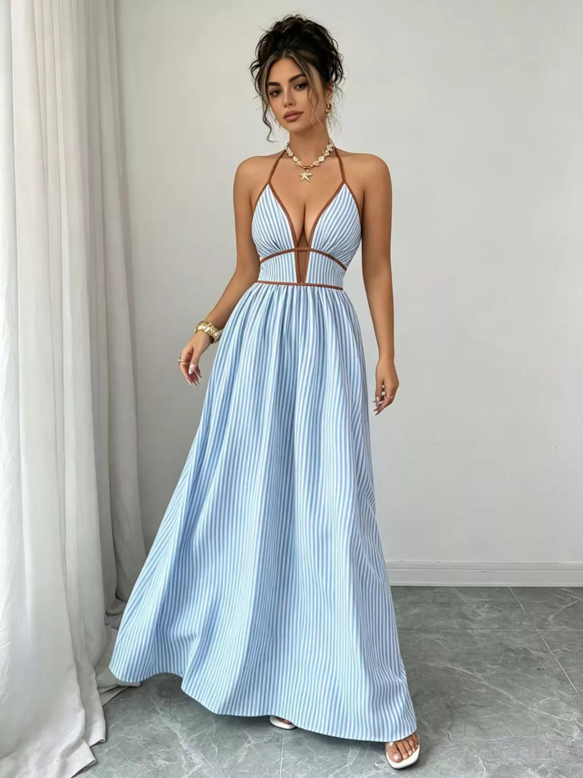 Front view of light blue halter maxi dress with deep neckline and flowing skirt