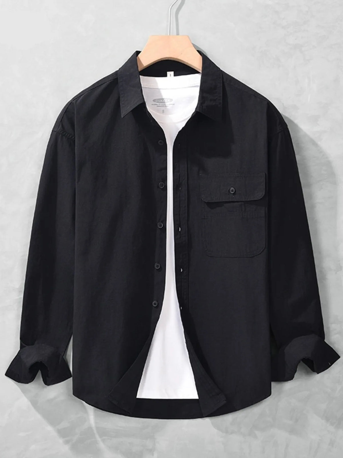 Black long-sleeve men's button-up shirt shown from the front with collar and chest pocket