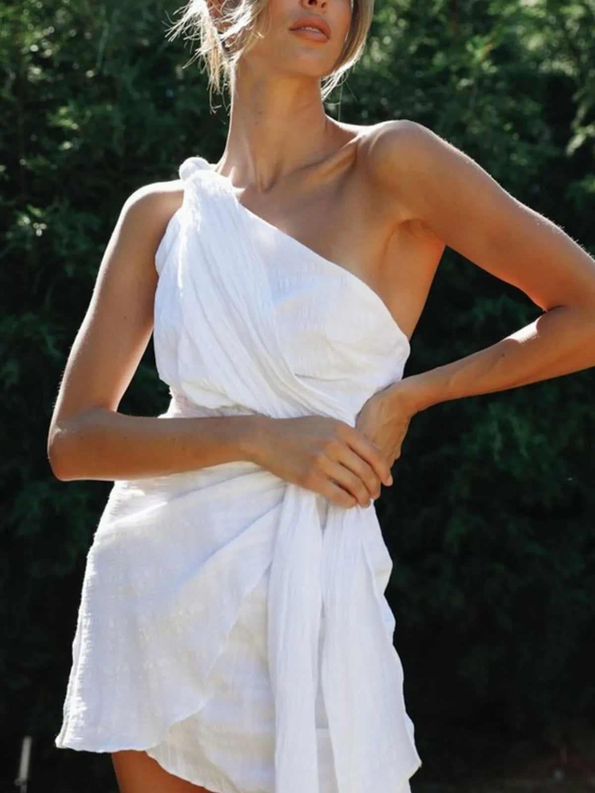 Front view showing the white dress's diagonal bodice and tied waist detail