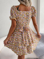 Rear view of yellow floral mini dress with flared skirt and short sleeves