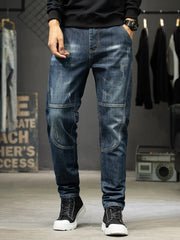 Front view of men's dark blue slim-fit jeans with faded thighs and stitched knee panels