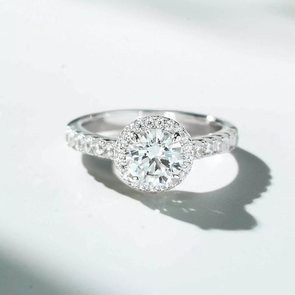 Round clear center stone ring with a halo and stone-set shoulders, shown from the front