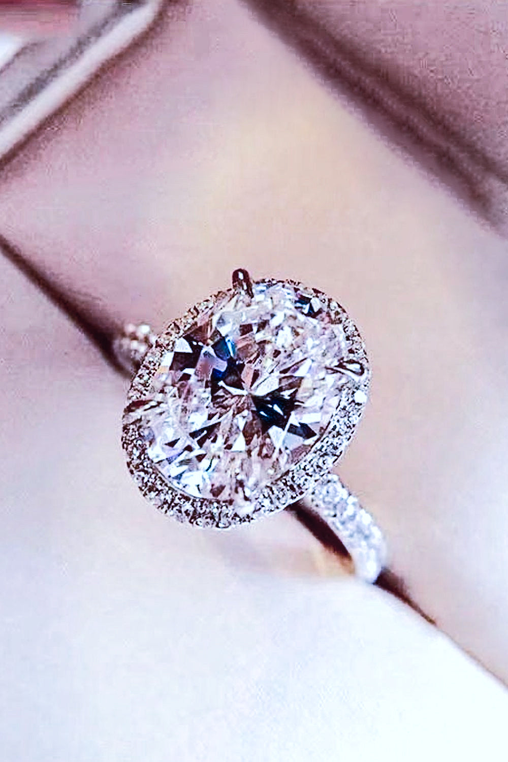 Side view of platinum-plated oval moissanite ring showing the raised setting