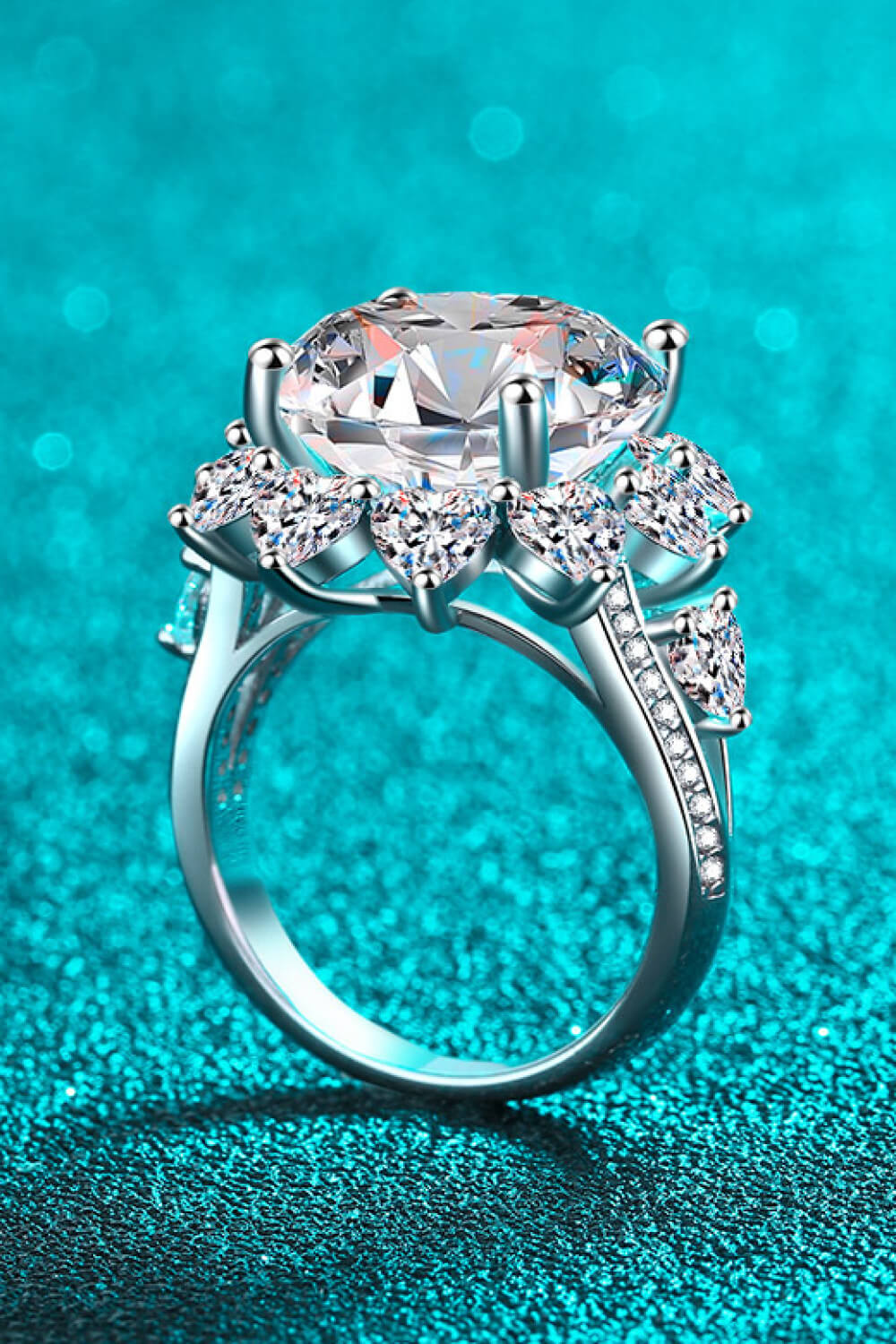 Side profile of silver flower-shaped moissanite ring with raised center stone and pavé band