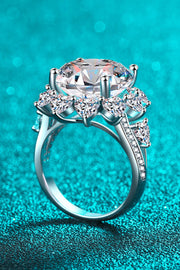 Side profile of silver flower-shaped moissanite ring with raised center stone and pavé band