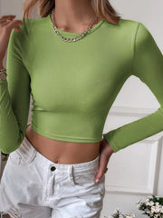 Model posing in the green fitted crop top with long sleeves